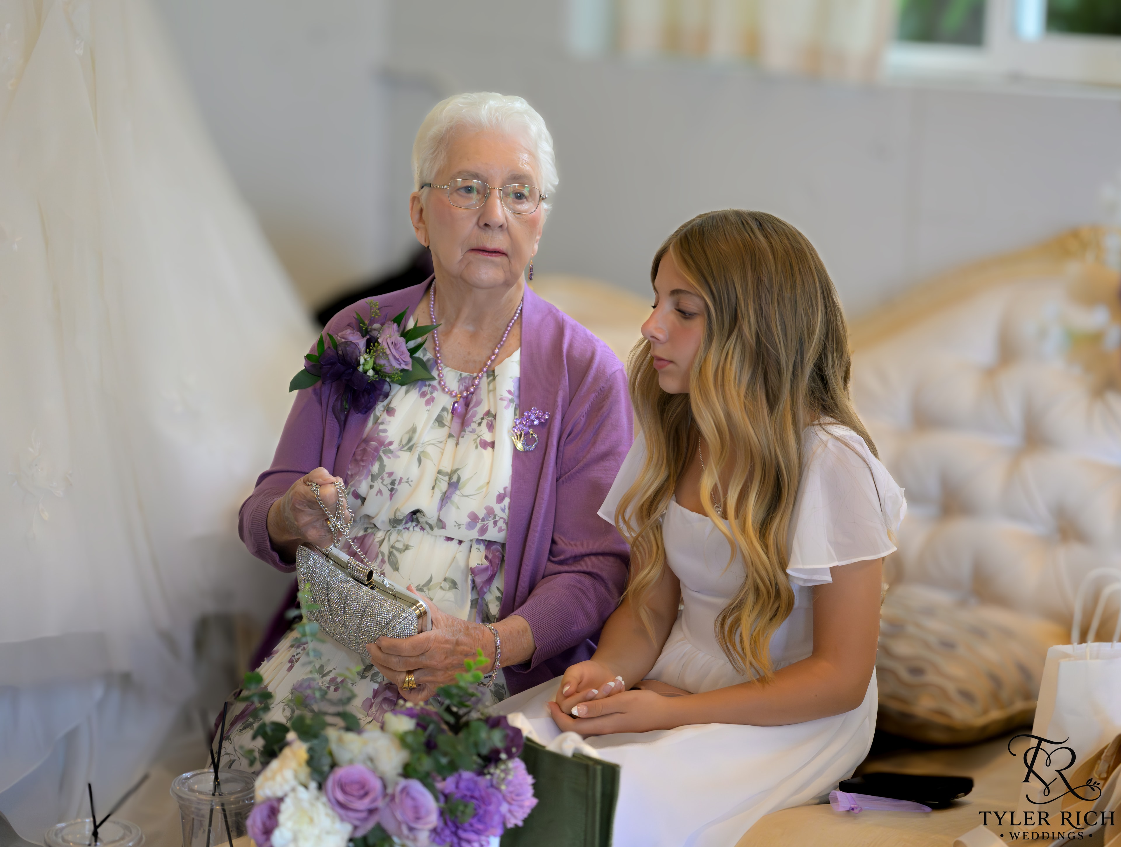 Grandmother and young woman at a bridal shop with purple florals
