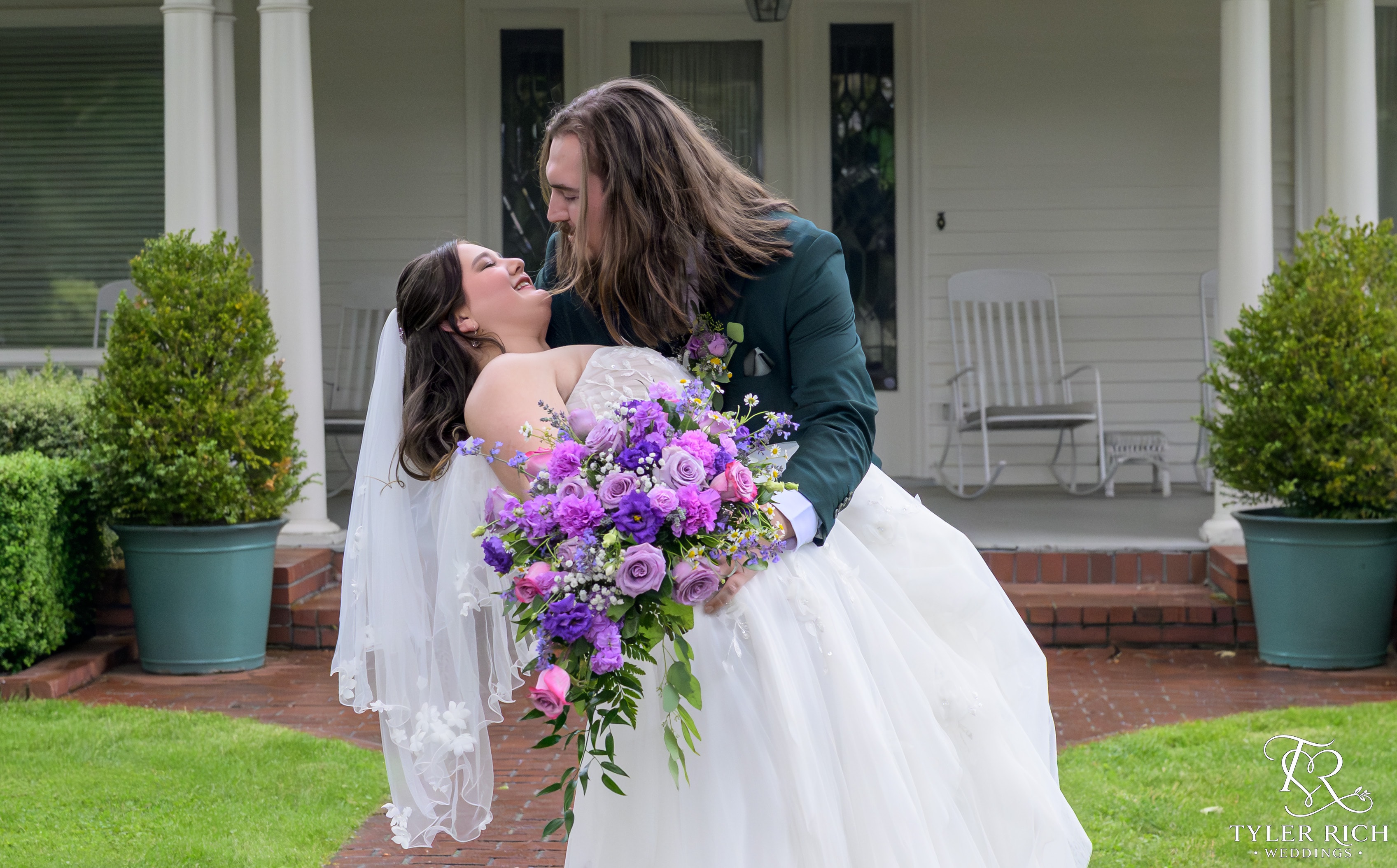 Groom dipping bride with purple bouquet